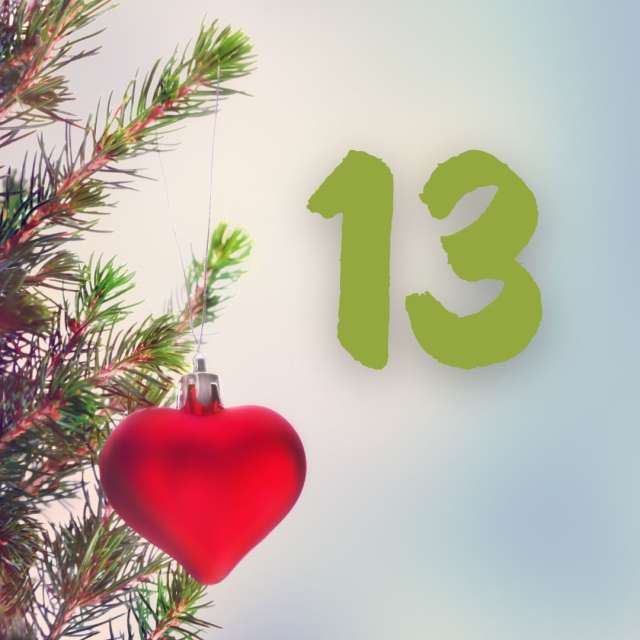 An einem Weihnachtsbaum hängt ein rotes Herz mit der Zahl 13.
